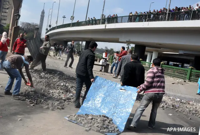 Egyptians clean up garbage and rocks from a street near Tahrir Square in downtown Cairo, Egypt, Saturday, Feb. 12, 2011. Egyptian protesters were jubilant Saturday over their success in ousting former President Hosni Mub...