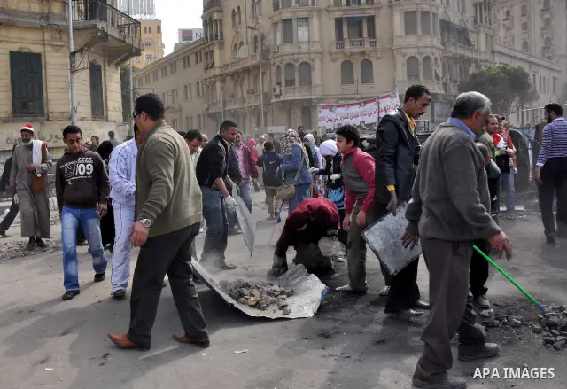 Egyptians clean up garbage and rocks from a street near Tahrir Square in downtown Cairo, Egypt, Saturday, Feb. 12, 2011. Egyptian protesters were jubilant Saturday over their success in ousting former President Hosni Mub...