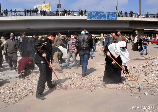 Egyptians clean up garbage and rocks from a street near Tahrir Square in downtown Cairo, Egypt, Saturday, Feb. 12, 2011. Egyptian protesters were jubilant Saturday over their success in ousting former President Hosni Mub...