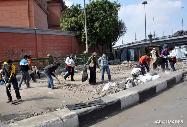 Egyptians clean up garbage and rocks from a street near Tahrir Square in downtown Cairo, Egypt, Saturday, Feb. 12, 2011. Egyptian protesters were jubilant Saturday over their success in ousting former President Hosni Mub...