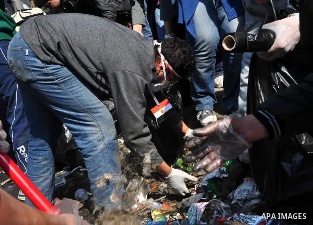 Egyptians clean up garbage and rocks from a street near Tahrir Square in downtown Cairo, Egypt, Saturday, Feb. 12, 2011. Egyptian protesters were jubilant Saturday over their success in ousting former President Hosni Mub...