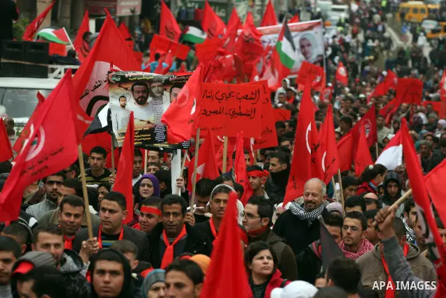 Palestinians wave red flags during a demonstration marking the 29th anniversary of the Palestinian People's Party, a socialist political party, in the West Bank city of Ramallah, Saturday, Feb. 12, 2011. Photo by Issam R...