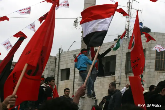 Palestinians wave an Egyptian flag and red flags during a demonstration marking the 29th anniversary of the Palestinian People's Party, a socialist political party, in the West Bank city of Ramallah, Saturday, Feb. 12, 2...