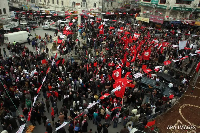 Palestinians wave an Egyptian flag and red flags during a demonstration marking the 29th anniversary of the Palestinian People's Party, a socialist political party, in the West Bank city of Ramallah, Saturday, Feb. 12, 2...