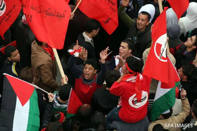 Palestinians wave red flags during a demonstration marking the 29th anniversary of the Palestinian People's Party, a socialist political party, in the West Bank city of Ramallah, Saturday, Feb. 12, 2011. Photo by Issam R...