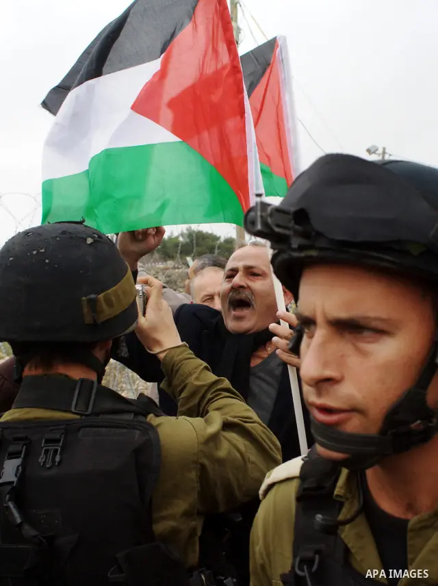 A Palestinian demonstrator argues with an Israeli soldier during a protest against Israel's controversial separation barrier organized by Palestinian and foreign peace activists in the West Bank village of Beit Omar, nea...