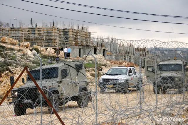 Israeli soldiers stand guards during a protest against Israel's controversial separation barrier organized by Palestinian and foreign peace activists in the West Bank village of Beit Omar, near Hebron, on 12 February 201...