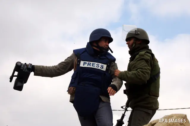 An Israeli soldier scuffles with a cameraman during a protest against Israel's controversial separation barrier organized by Palestinian and foreign peace activists in the West Bank village of Beit Omar, near Hebron, on...