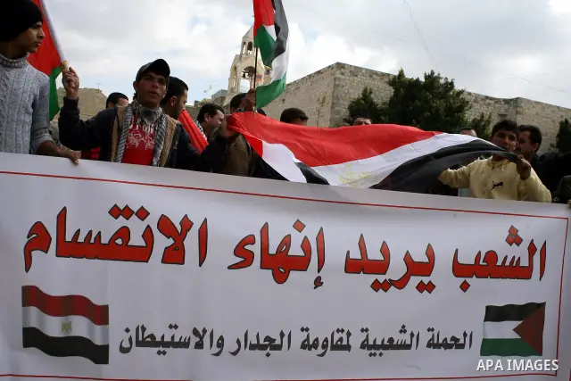 Palestinians hold Egypt and Palestine flags during a protest outside the Church of the Nativity in the West Bank town of Bethlehem 13 February 2011, to show support for the people of Egypt. Photo by Najeh Hashlamoun