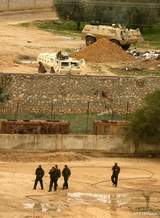 Egyptian soldiers patrol with their army vehicles (rear) their side of the border as Hamas policemen (front) walk along their side of the frontier in this picture taken from the southern Gaza Strip town of Rafah on Febru...