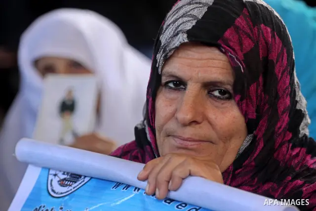 Palestinian women hold pictures of jailed relatives during a protest calling for the release of Palestinian prisoners from Israeli jails at the Red Cross office in Gaza City on Feb. 14,2011. Photo by Mohammed Asad