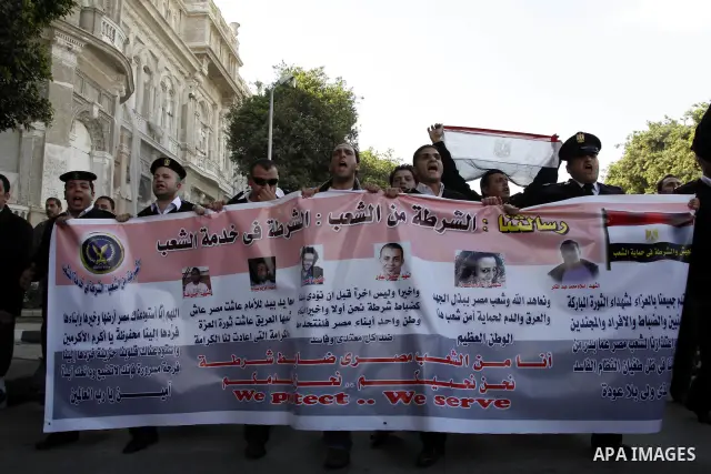Egyptian police officers and protesters shout ''The police and the people are one hand', in Tahrir Square in downtown Cairo, Egypt Feb. 14, 2011. Egypt's military is taking down the makeshift tents of protesters who camp...