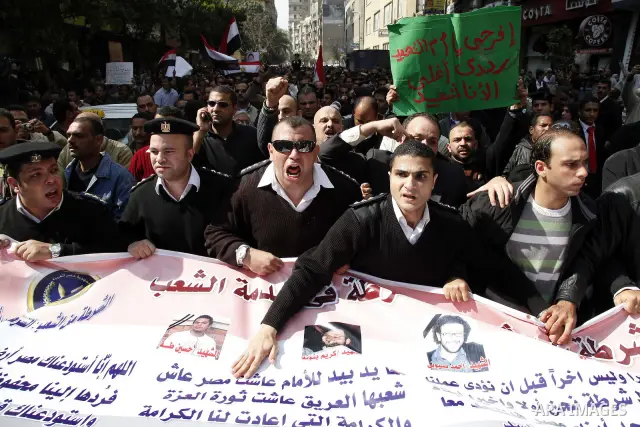 Egyptian police officers and protesters shout ''The police and the people are one hand', in Tahrir Square in downtown Cairo, Egypt Feb. 14, 2011. Egypt's military is taking down the makeshift tents of protesters who camp...