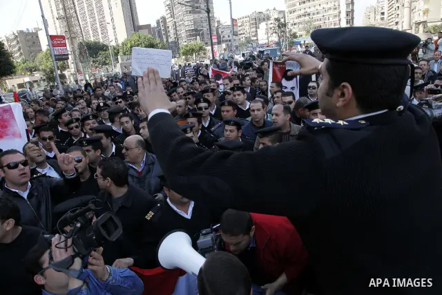 Egyptian police officers and protesters shout ''The police and the people are one hand', in Tahrir Square in downtown Cairo, Egypt Feb. 14, 2011. Egypt's military is taking down the makeshift tents of protesters who camp...