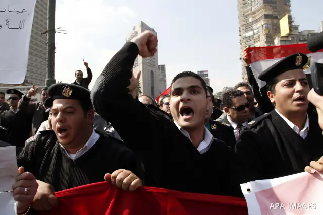 Egyptian police officers and protesters shout ''The police and the people are one hand', in Tahrir Square in downtown Cairo, Egypt Feb. 14, 2011. Egypt's military is taking down the makeshift tents of protesters who camp...