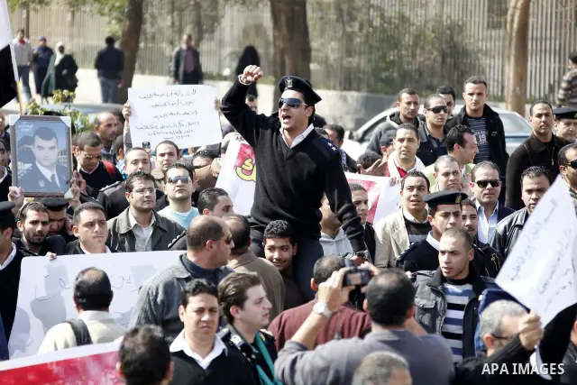 Egyptian police officers and protesters shout ''The police and the people are one hand', in Tahrir Square in downtown Cairo, Egypt Feb. 14, 2011. Egypt's military is taking down the makeshift tents of protesters who camp...