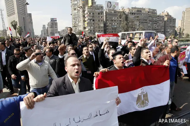Egyptian police officers and protesters shout ''The police and the people are one hand', in Tahrir Square in downtown Cairo, Egypt Feb. 14, 2011. Egypt's military is taking down the makeshift tents of protesters who camp...