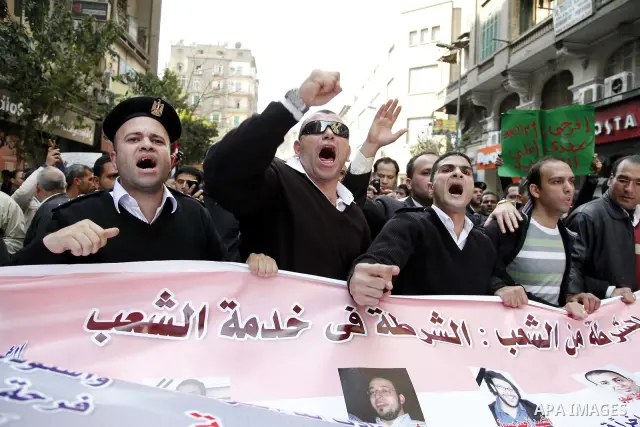 Egyptian police officers and protesters shout ''The police and the people are one hand', in Tahrir Square in downtown Cairo, Egypt Feb. 14, 2011. Egypt's military is taking down the makeshift tents of protesters who camp...