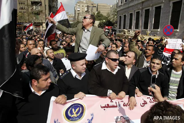 Egyptian police officers and protesters shout ''The police and the people are one hand', in Tahrir Square in downtown Cairo, Egypt Feb. 14, 2011. Egypt's military is taking down the makeshift tents of protesters who camp...
