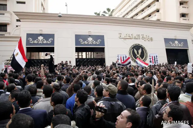 Egyptian police officers and protesters shouts 'The police and the people are one hand', In front of the Ministry of Interior in downtown Cairo, Egypt , Feb. 14, 2011. Egypt's military is taking down the makeshift tents...