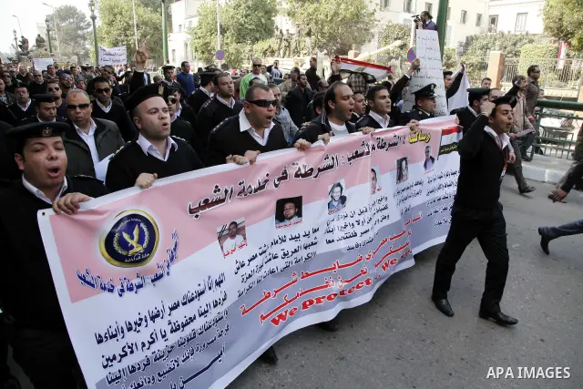 Egyptian police officers and protesters shout ''The police and the people are one hand', in Tahrir Square in downtown Cairo, Egypt Feb. 14, 2011. Egypt's military is taking down the makeshift tents of protesters who camp...