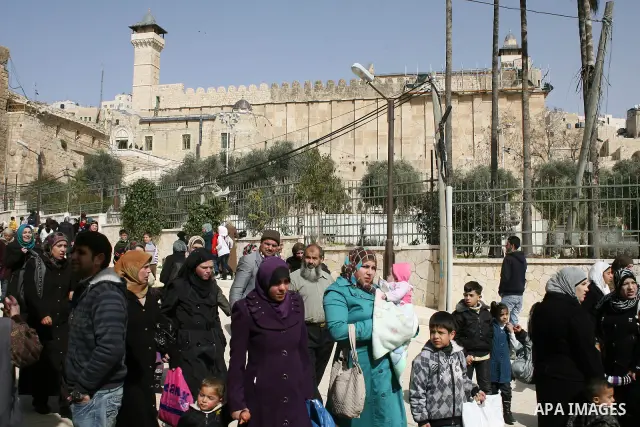 Palestinians go to Ibrahimi mosque as they march in a procession to mark the birth anniversary of Islam's prophet Mohammed, in the West Bank city of Hebron Tuesday, Feb. 15, 2011. Muslims celebrate Prophet Mohammed's bir...