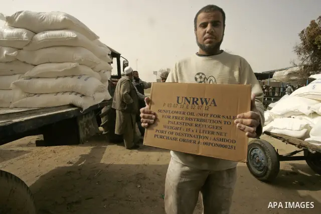 Palestinians receive food aids from the United Nations Relief and Works Agency (UNRWA) at the Rafah refugee camp, in the southern Gaza Strip on February 16, 2011. Accused the owners of destroyed houses that the Relief an...