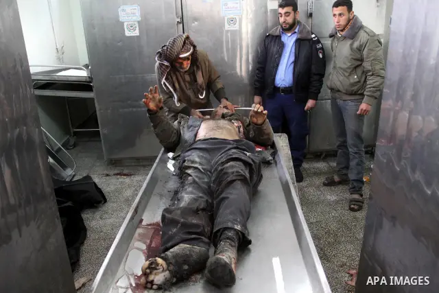 Palestinians look at the body of one of the three killed Palestinians, at the morgue in Kamal Adwan hospital in the town of Beit Lahiya, northern Gaza Strip, on Feb. 17, 2011. Three Palestinian fishermen were slain on ea...