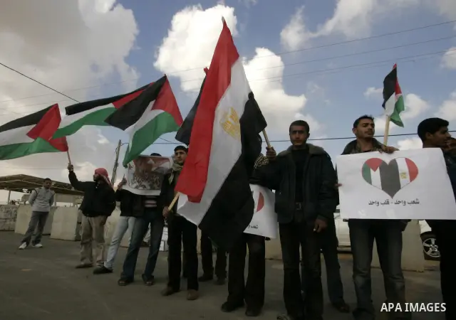Palestinian youths take part in a march to show support for the Egyptian protesters in Egypt who forced their President Hosni Mubarak to resign, in front of the Rafah border crossing, southern Gaza Strip with Egypt on Fe...
