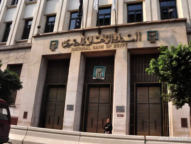 Egyptians walk in front of an Egyptian bank in Cairo, Egypt on Feb 17,2011. Mubarak's departure set off a chain reaction around the Middle East, with anti-government demonstrations reported Wednesday in Libya, Bahrain, J...