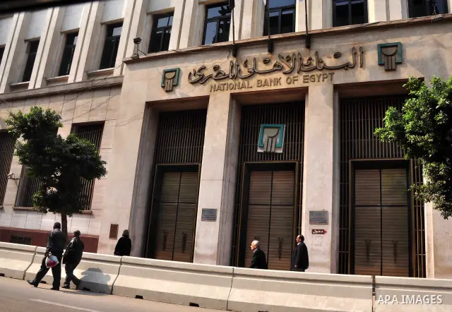 Egyptians walk in front of an Egyptian bank in Cairo, Egypt on Feb 17,2011. Mubarak's departure set off a chain reaction around the Middle East, with anti-government demonstrations reported Wednesday in Libya, Bahrain, J...