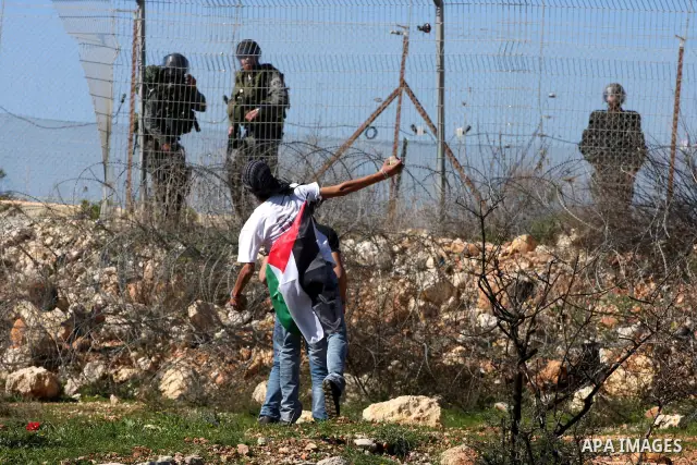 Palestinian protesters hurl stones towards Israeli soldiers during the weekly demonstration against Israel's separation barrier in the West Bank village of Bilin near Ramallah, Friday, Feb. 18, 2011. Photo by Issam Rimaw...