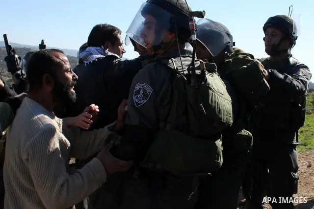 Israeli soldiers scuffle with Palestinian protesters during the weekly demonstration against Israel's separation barrier in the West Bank village of Bilin near Ramallah, Friday, Feb. 18, 2011. Photo by Issam Rimawi