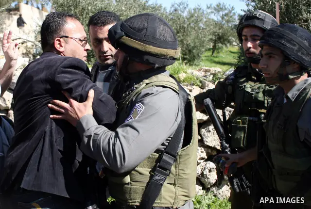 Israeli soldiers argue with Palestinian, Israeli and International protesters during a demonstration against Israel's controversial separation barrier in the West Bank village of Maasarah, near the biblical town of Bethl...