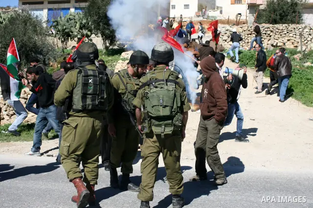Israeli soldiers fire tear gas canisters towards Palestinian ,Israeli and International protesters during a demonstration against Israel's controversial separation barrier in the West Bank village of Maasarah, near the b...
