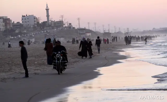 Palestinians walk at Gaza city beach on Feb 18,2011 after the increasing of temperature in Gaza Strip. Photo by Mohammed Asad