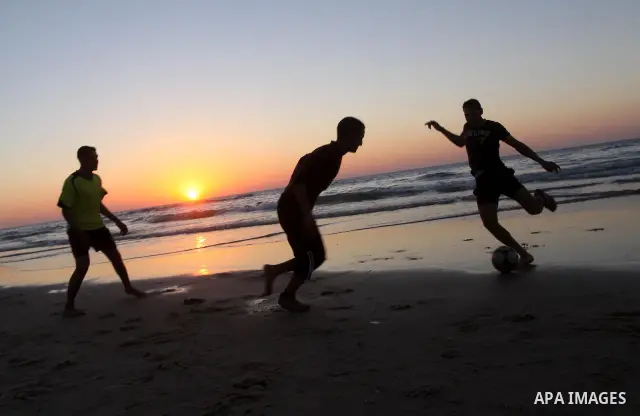 Palestinian youths play football at Gaza city beach on Feb 18,2011 after the increasing of temperature in Gaza Strip. Photo by Mohammed Asad