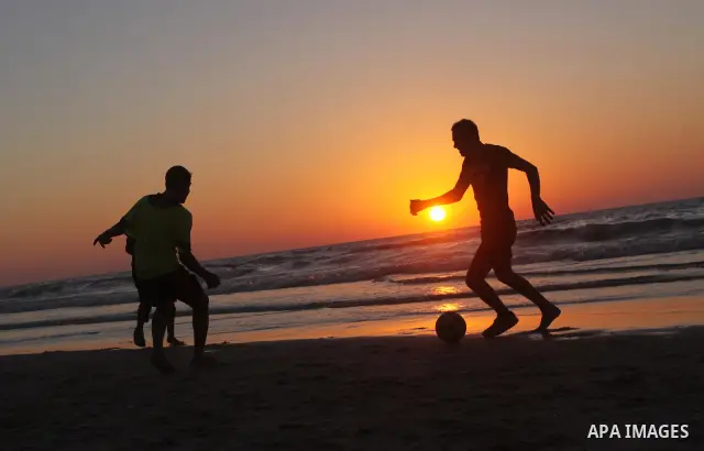 Palestinian youths play football at Gaza city beach on Feb 18,2011 after the increasing of temperature in Gaza Strip. Photo by Mohammed Asad