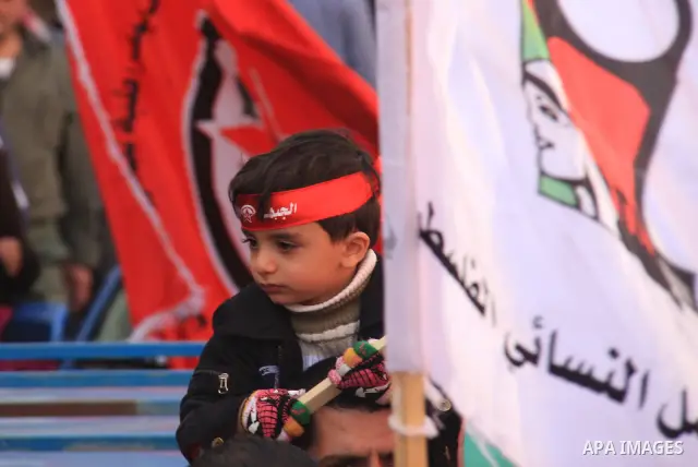 A Palestinian boy takes part during a demonstration calling to end the split between the West Bank and Gaza, marking the 42th anniversary of the Democratic Front for the Liberation of Palestine (DFLP) in the West Bank ci...