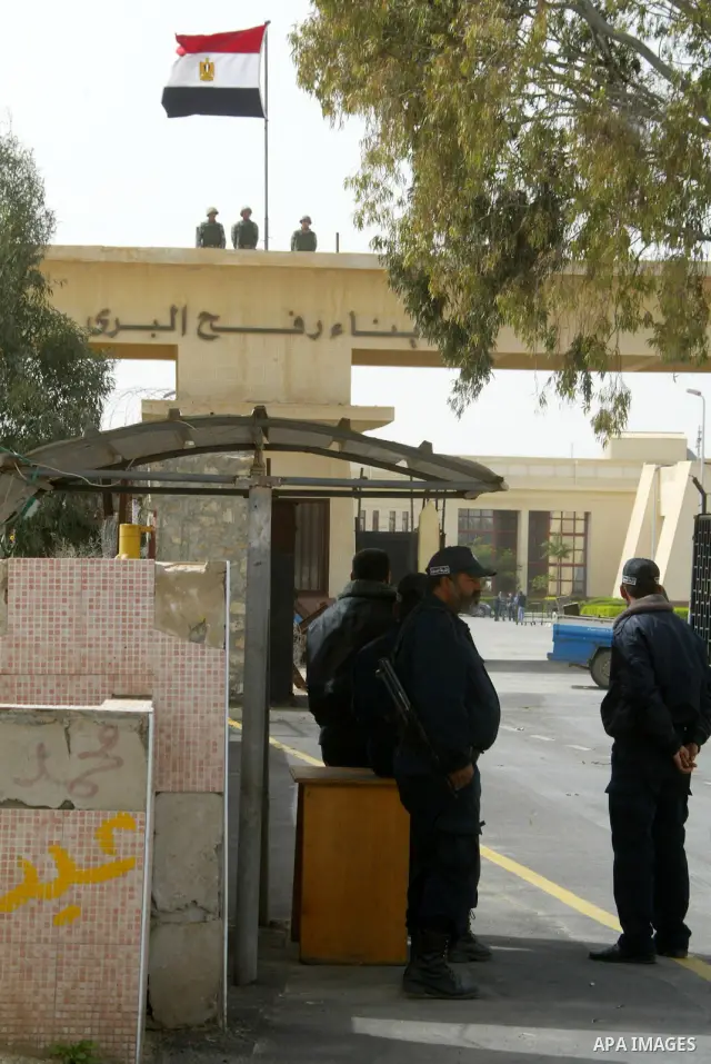Egyptian soldiers (top) keep watch on the Egyptian side of the Rafah border crossing as Hamas policemen stand guard on the Palestinian side on February 19, 2011. The Egyptian authorities reopened the Rafah crossing on it...