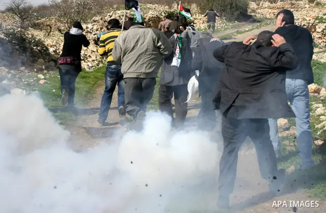 Israeli soldiers fire tear gas towards Palestinian ,Israeli and International protesters during a demonstration against the demolishing of farm land to be used in the construction of Jewish settlements near the existing...