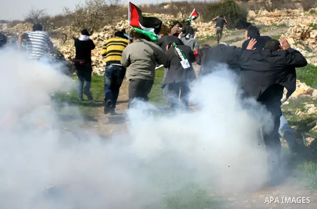 Israeli soldiers fire tear gas towards Palestinian ,Israeli and International protesters during a demonstration against the demolishing of farm land to be used in the construction of Jewish settlements near the existing...