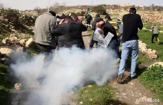 Israeli soldiers fire tear gas towards Palestinian ,Israeli and International protesters during a demonstration against the demolishing of farm land to be used in the construction of Jewish settlements near the existing...
