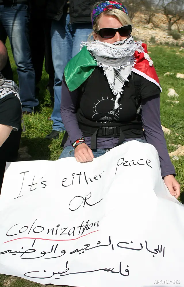 Palestinian, Israeli and foreign activists take part in a demonstration against the demolishing of farm land to be used in the construction of Jewish settlements near the existing Israeli settlement of Karmi Tsor near th...