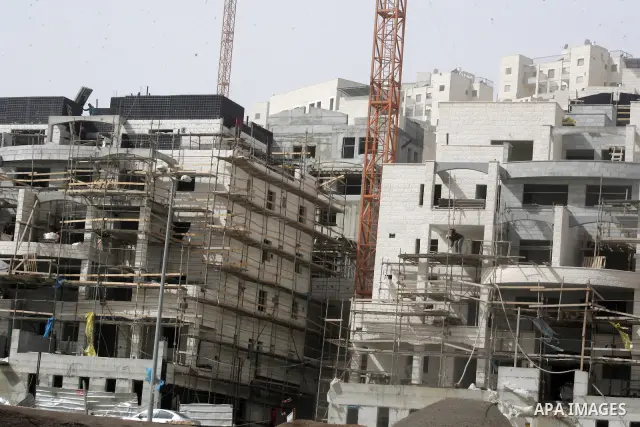 Palestinian labourers work at a construction site at the Jewish settlement in Harmoun Hanatsev in the east Jerusalem Feb. 20,2011. The United States vetoed a resolution that received 14 votes in favour from the United Na...