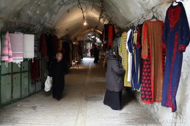 Palestinians shop in a traditional market at the old city in the West Bank city of Hebron on February 20, 2011. Photo by Najeh Hashlamoun