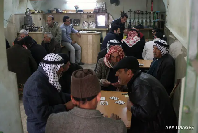 Palestinians sit in a coffee shop in a traditional market at the old city in the West Bank city of Hebron on February 20, 2011. Photo by Najeh Hashlamoun