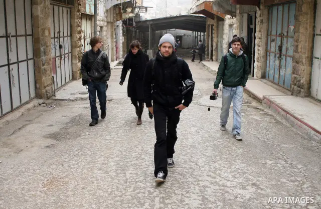 Foreigners shop in a traditional market at the old city in the West Bank city of Hebron on February 20, 2011. Photo by Najeh Hashlamoun