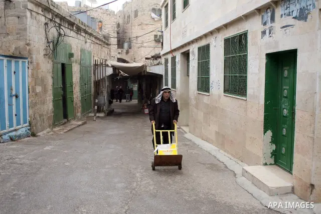 Palestinians shop in a traditional market at the old city in the West Bank city of Hebron on February 20, 2011. Photo by Najeh Hashlamoun