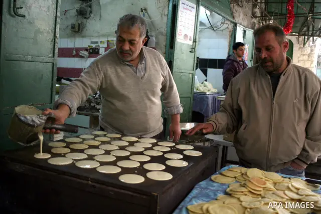 Palestinians shop in a traditional market at the old city in the West Bank city of Hebron on February 20, 2011. Photo by Najeh Hashlamoun